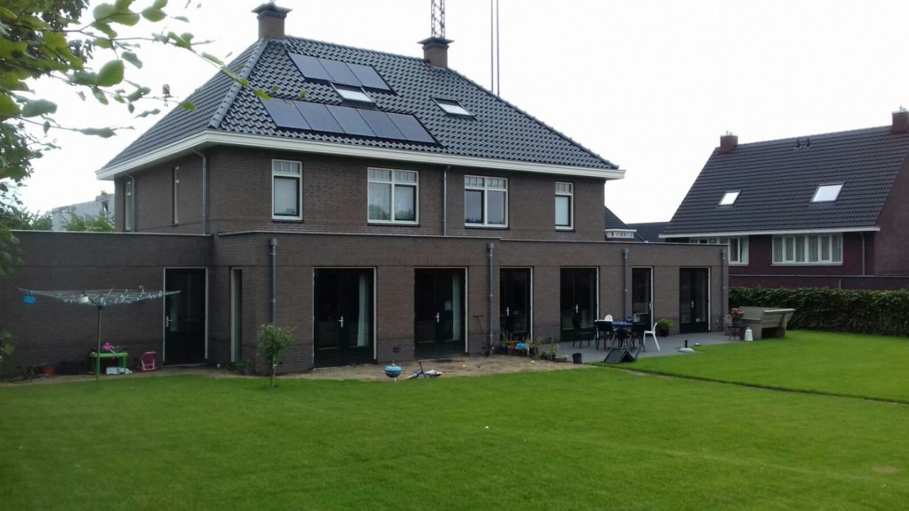 De woningen gezien vanaf de tuinzijde. Opgenomen in het pannendak zijn PV-panelen.