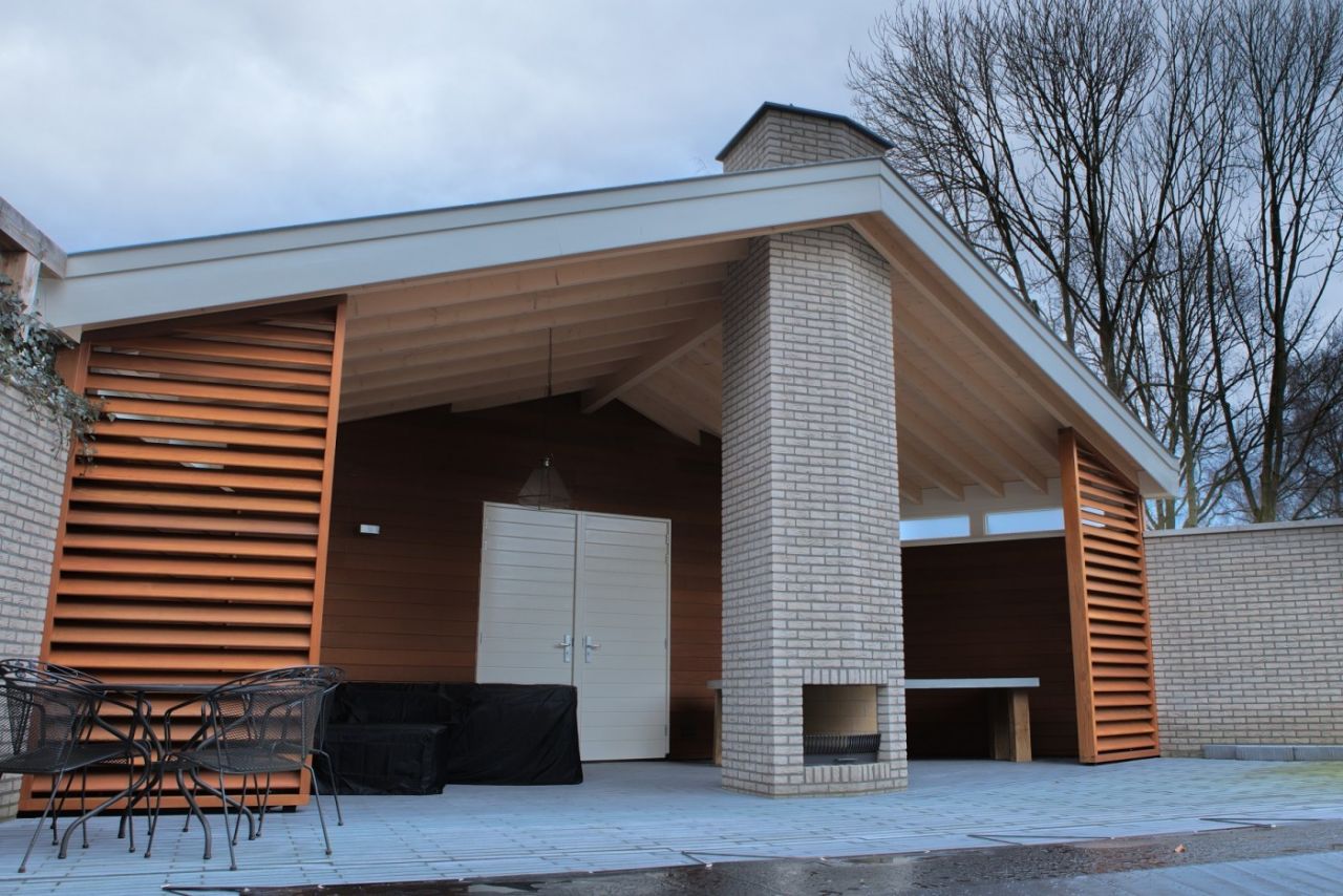 Bij het bouwen van dit buitenverblijf is veel hout toegepast. De haard en zwembad completeren het geheel. 